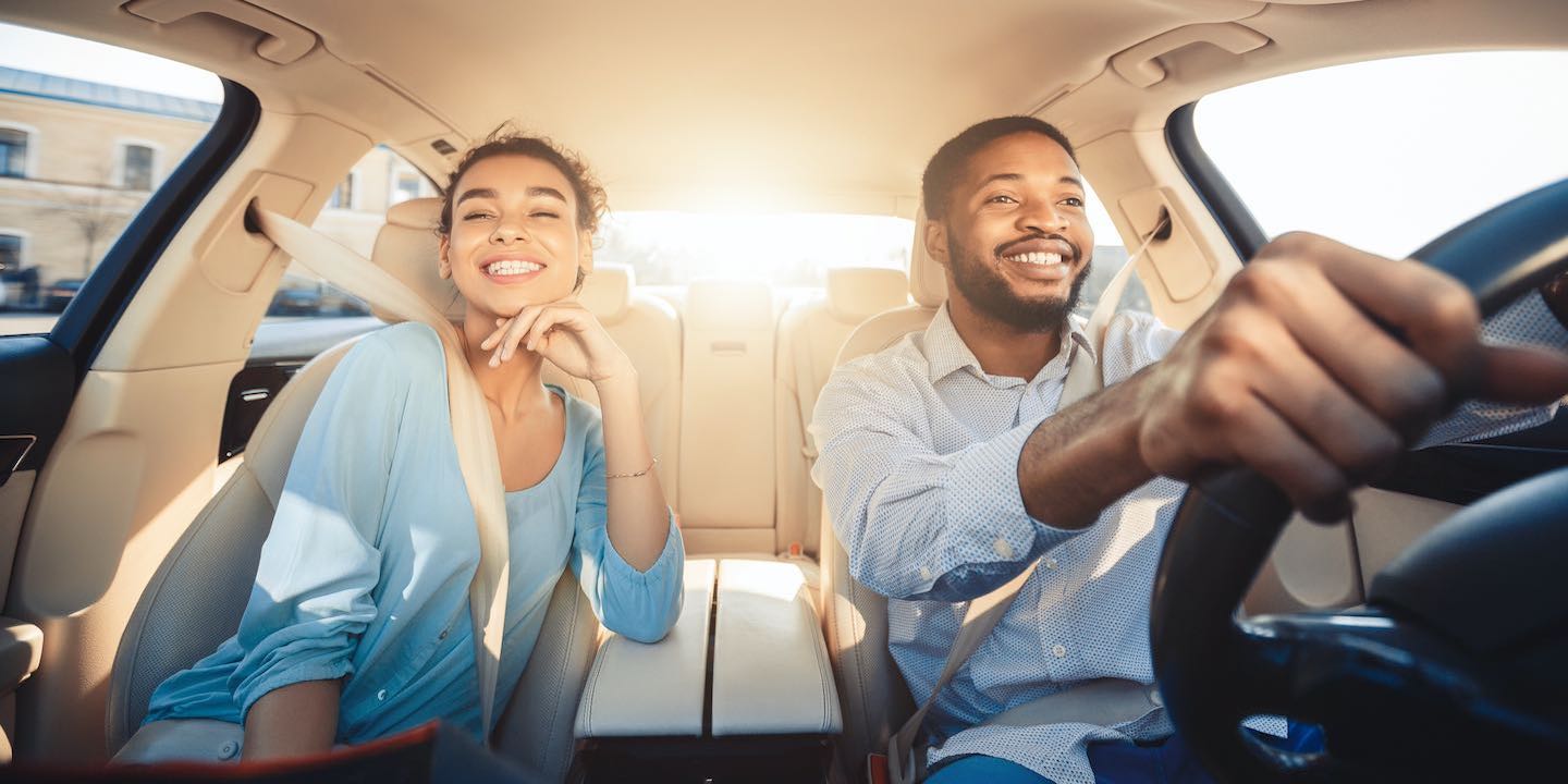young couple smiling in new car