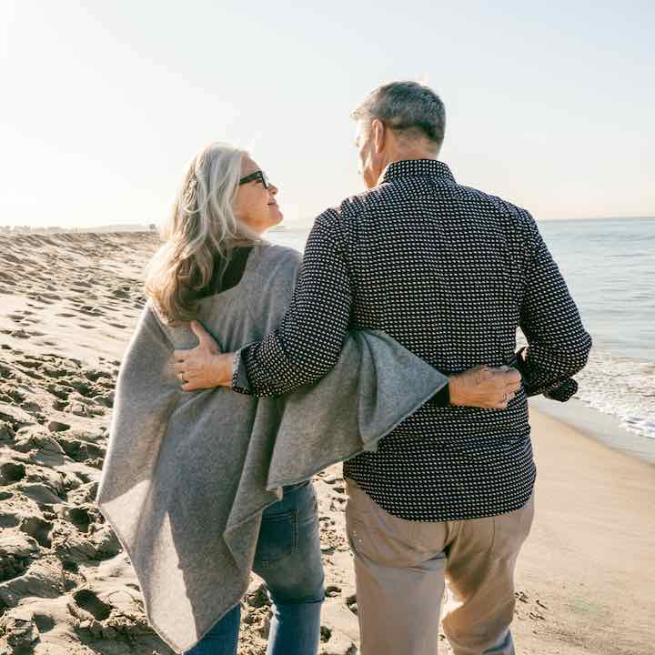 retired couple walking on the beach